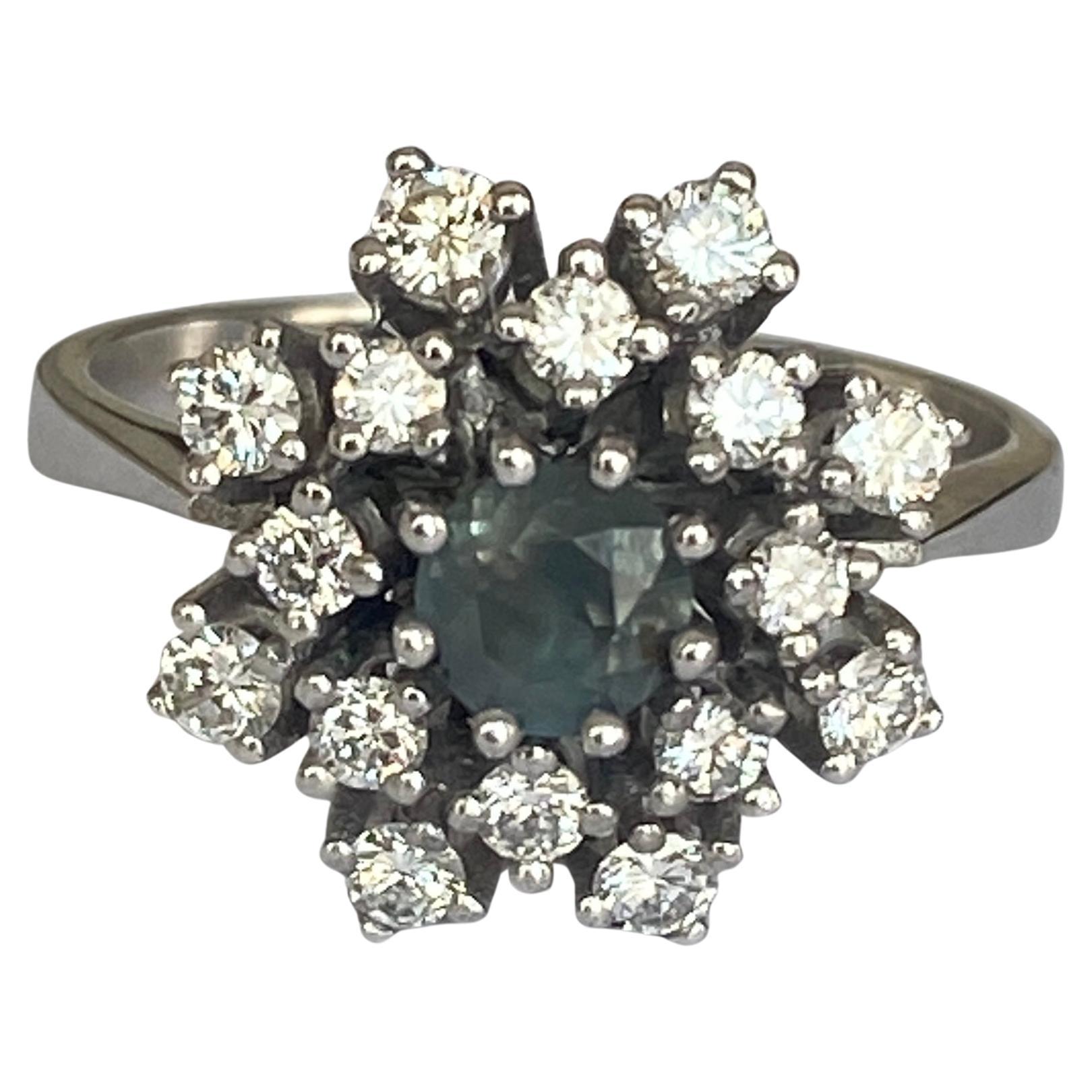 Dieser Ring aus 14-karätigem Weißgold enthält einen natürlichen Alexandrit von 0,60 Karat im Mischschliff, der von 16 Diamanten im Brillantschliff von ca. 0,70 Karat G/VVS/VS umgeben ist. Die Farbe des Steins wechselt von grün zu violett.