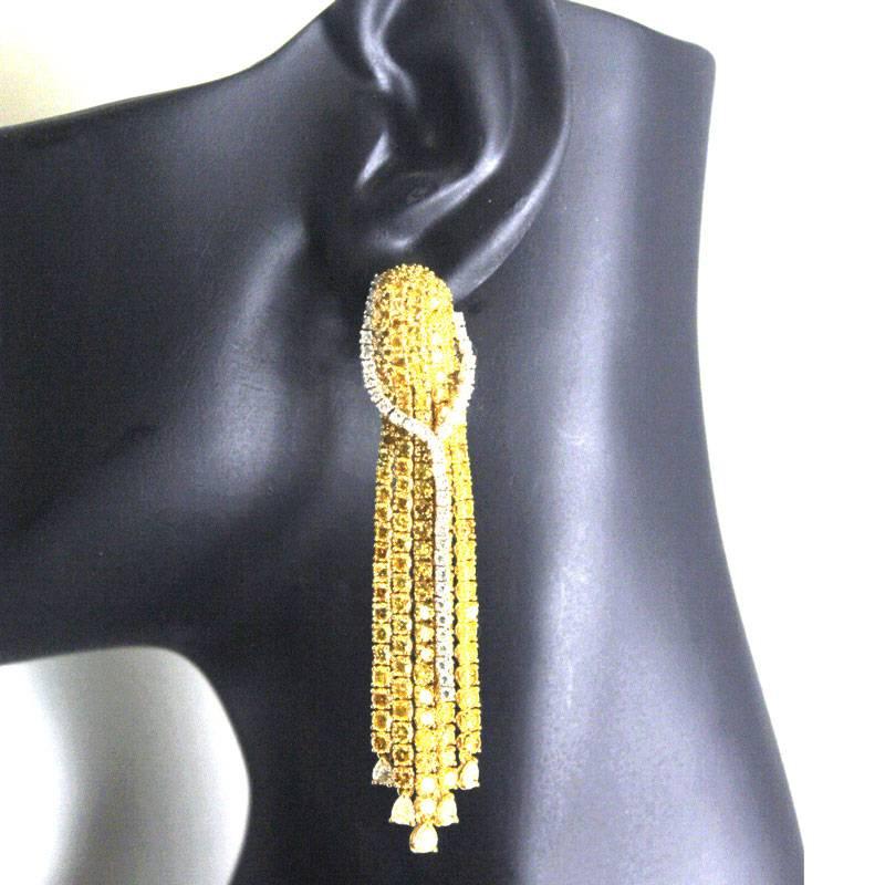 These stunning multi-strand diamond dangle earrings feature 282 treated yellow diamonds. At the end of each strand is a white pear shaped diamond. On each earring there is also a single Y shaped strand of white diamonds overlaying the yellow diamond
