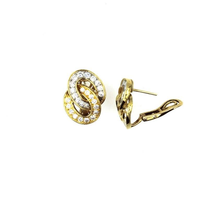 These gorgeous earrings by designer Verger Freres feature two interlocking diamond hoops set in 18 karat white and yellow gold. There are a total of 52 round brilliant cut diamonds equaling approximately 2.0 CTTW. The diamonds are graded E/F color,