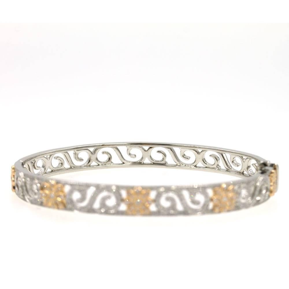 This elegant Enchant Scroll diamond bangle bracelet by Tiffany & Company is a current piece from their collection. The brilliant diamonds accentuate the ornate swirl motif. The .64 carats of diamonds are set in platinum and 18 karat rose gold. The