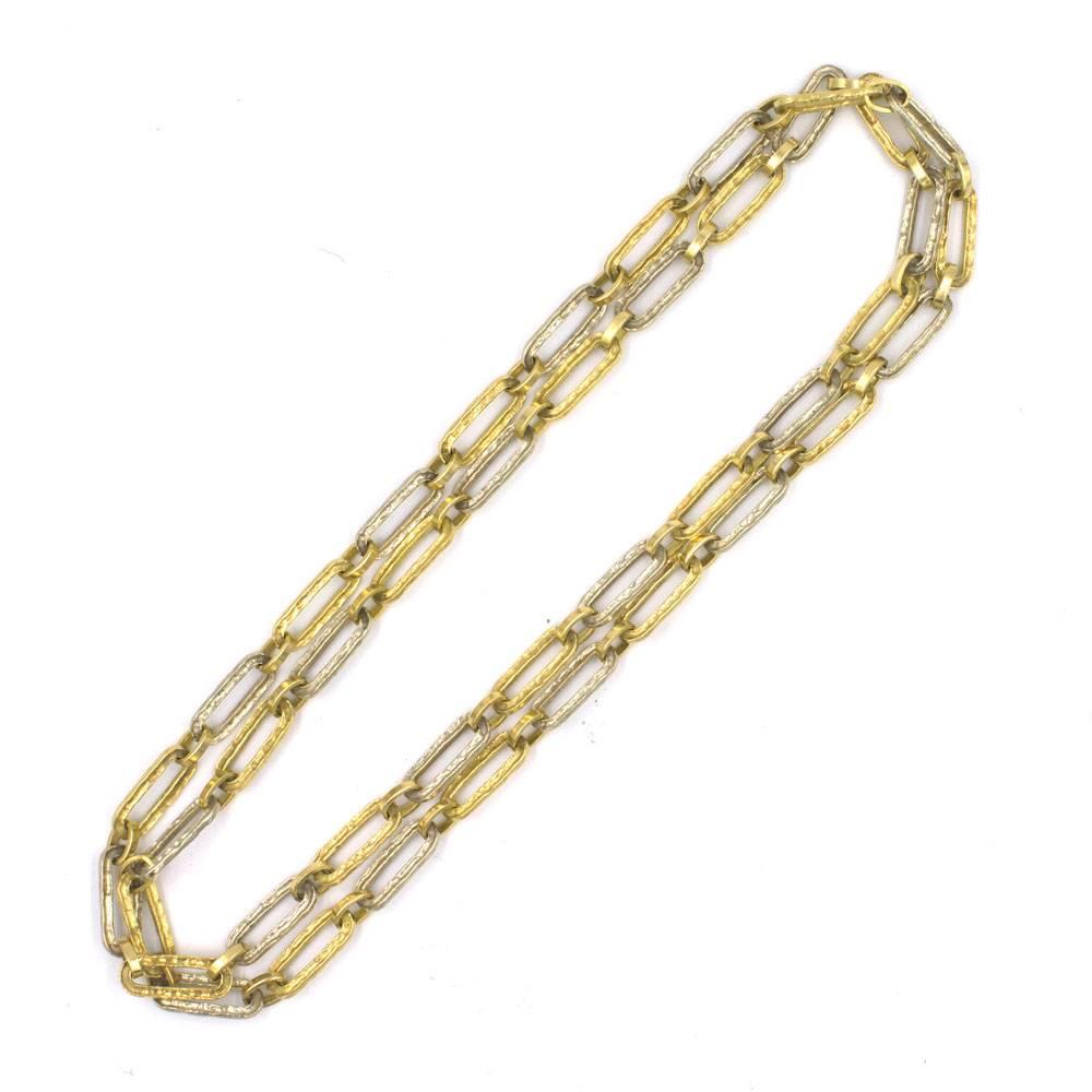 Timeless gold link chain features oval hammered links of white and yellow 18 karat gold to form a 32 inch necklace. The beautifully crafted necklace weighs 52 grams and is a great staple for any wardrobe. 