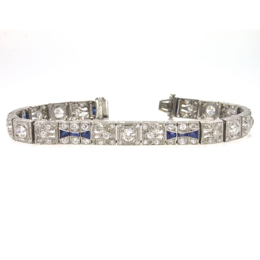 This exquisite Art Deco bracelet features Old European Cut diamonds and synthetic sapphire accents. The platinum bracelet houses approximately 5.0 carat total weight of diamonds graded H-I color and VS clarity. It measures 7 inches in length and