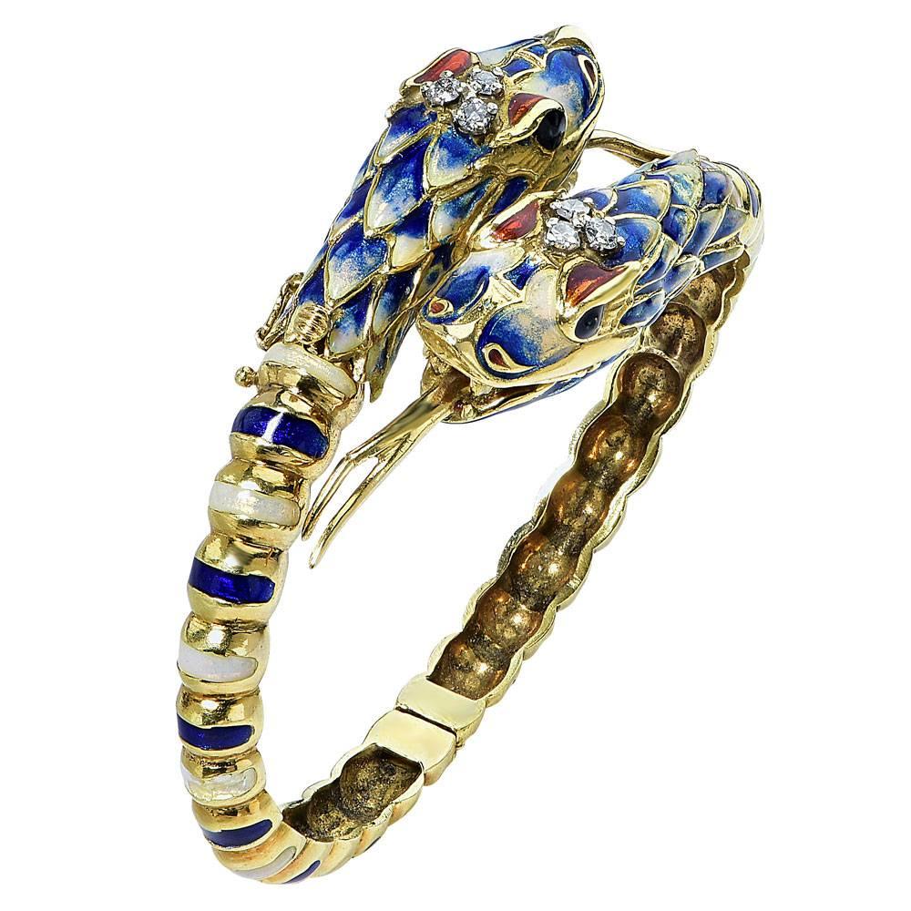 This fabulous intricate bracelet is a true piece of art. The two snake faces bypass each other, and underneath is the hidden clasp. The bangle is fashioned in 18 karat yellow gold, enamel, and six single cut diamonds. The diamonds equal