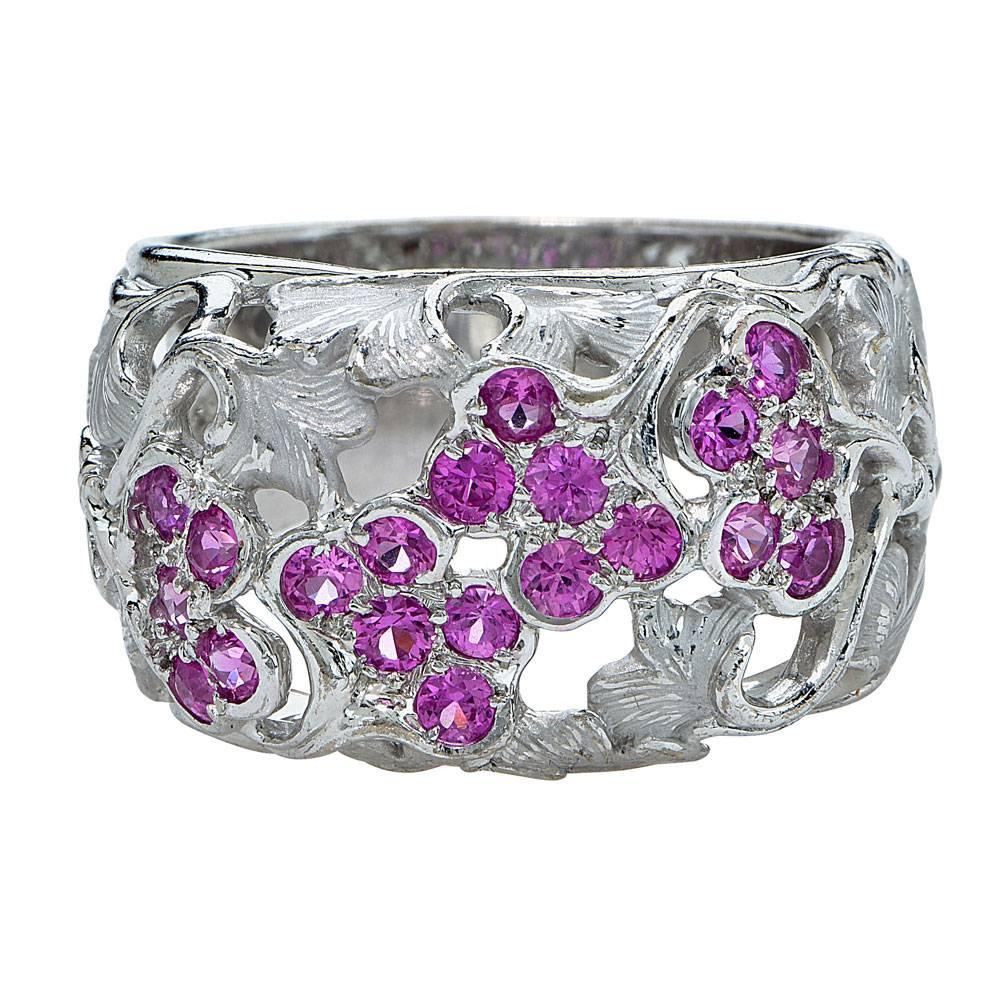 Fabulous pink sapphire leaf ring crafted by world renowned designer Carrera y Carrera. This beautifully crafted ring features 20 bezel set pink sapphire gemstones in a leaf carved 18 karat white gold band. The ring is size 6.5, but is sizable. The