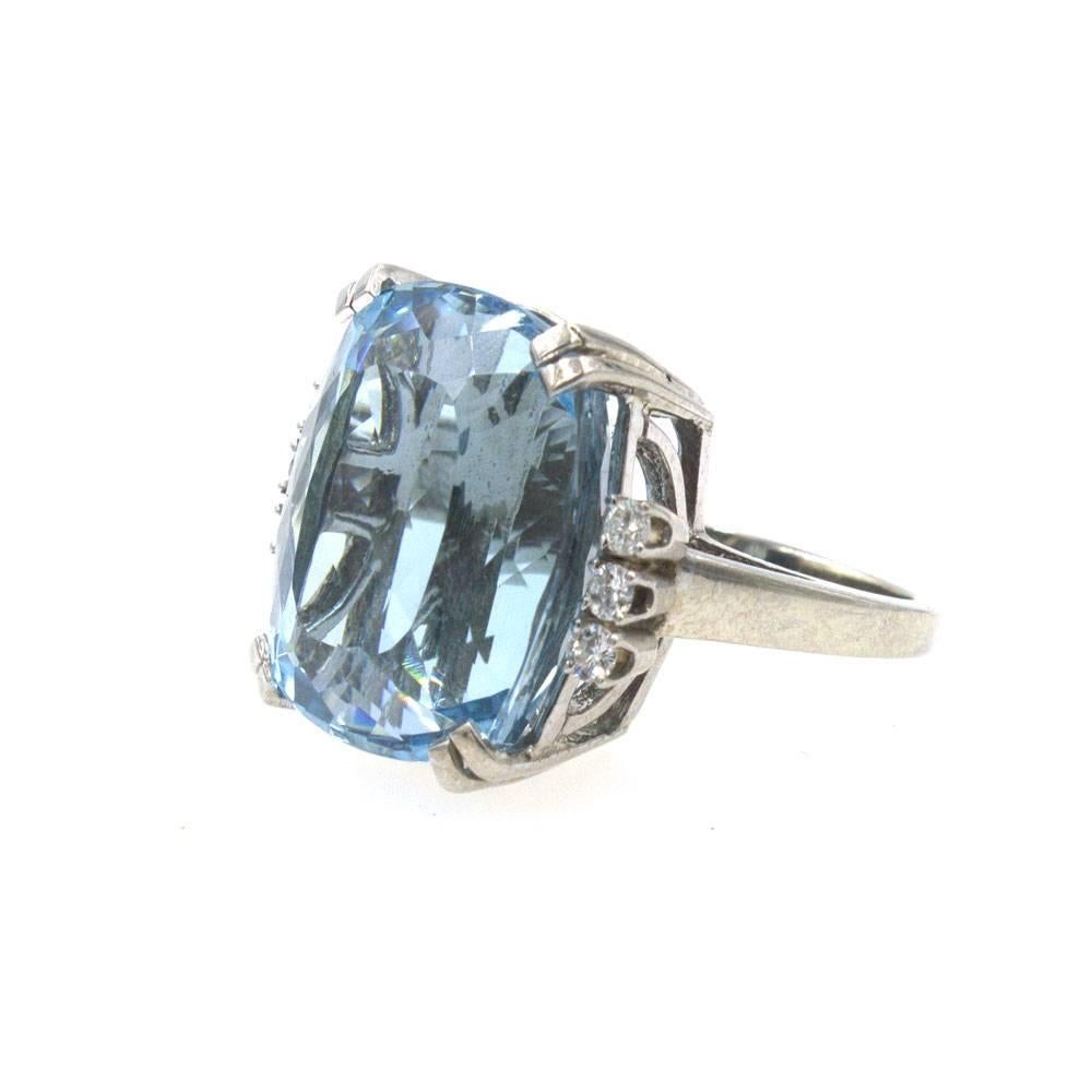 Fabulous 24-Carat Aquamarine and Diamond Ring. This gorgeous ring features a cushion shape blue aquamarine gemstone set with 6 side diamonds that equal approximately .25 cttw. The aquamarine measures approximately 19.5 x 16.5 mm. The ring is