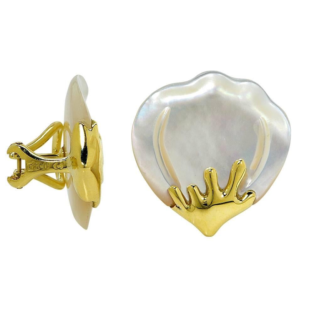 Tiffany & Company carved mother of pearl and 18 karat yellow gold fashion earrings. These timeless earrings feature carved mother of pearl fan shaped tops and 18 karat yellow gold bottoms.  They measure approximately 1.0 x 1.0 inches, have lever