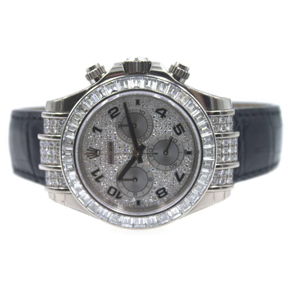 This unused Rolex Cosmograph Daytona Unisex Watch features a 18k white gold case set with 48 diamonds and a black leather strap. The Bezel is set with another 36 baguette diamonds. The pave diamond dial with silver-tone hands features enamel Arabic