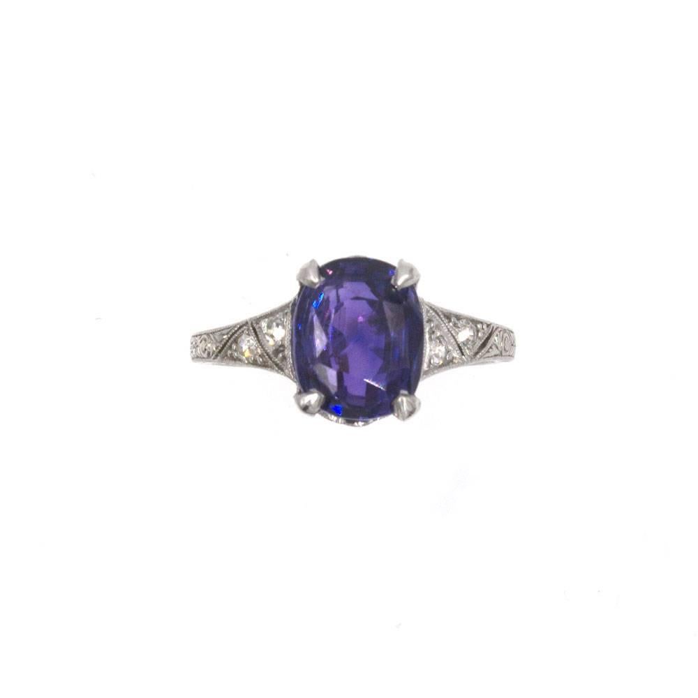 This Natural 5.11-Carat Color Change Sapphire has been certified by the AGL. The cushion shaped sapphire is a no heat Ceylon Sapphire. The sapphire is set in a vintage platinum mounting which features .14 carat total weight of diamonds.  The ring is