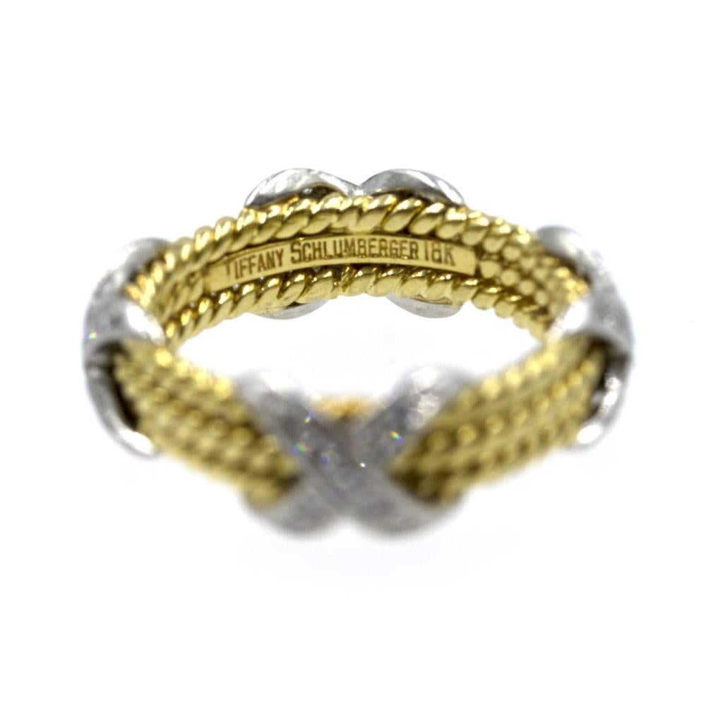 This popular and fashionable diamond 'X' ring was designed by Jean Schlumberger for Tiffany & Company. The three rope bands in 18 karat yellow gold are embellished with four diamond 'X' in 18 karat white gold. The ring is size 5.5, and measures