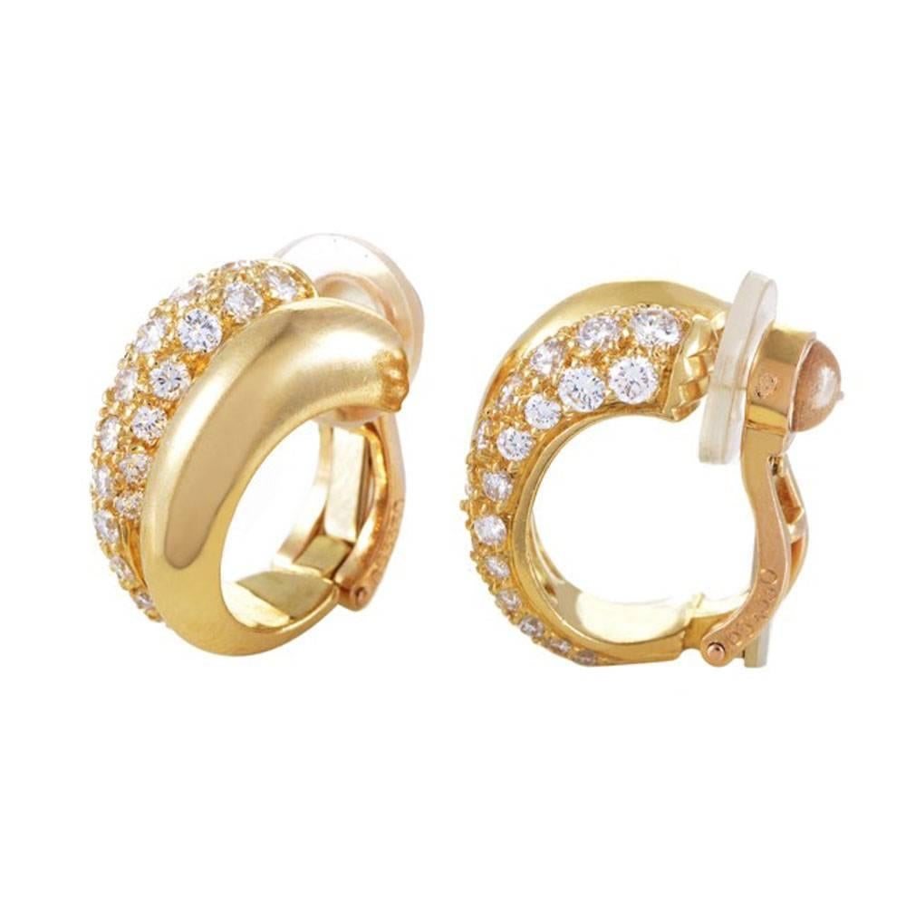 These timeless Cartier huggie earrings are fashioned in 18 karat yellow gold and pave set round brilliant cut diamonds. The approximately 1.15 cttw of pave set diamonds are graded E/F color and VS clarity.  The earrings are clip-on, are signed