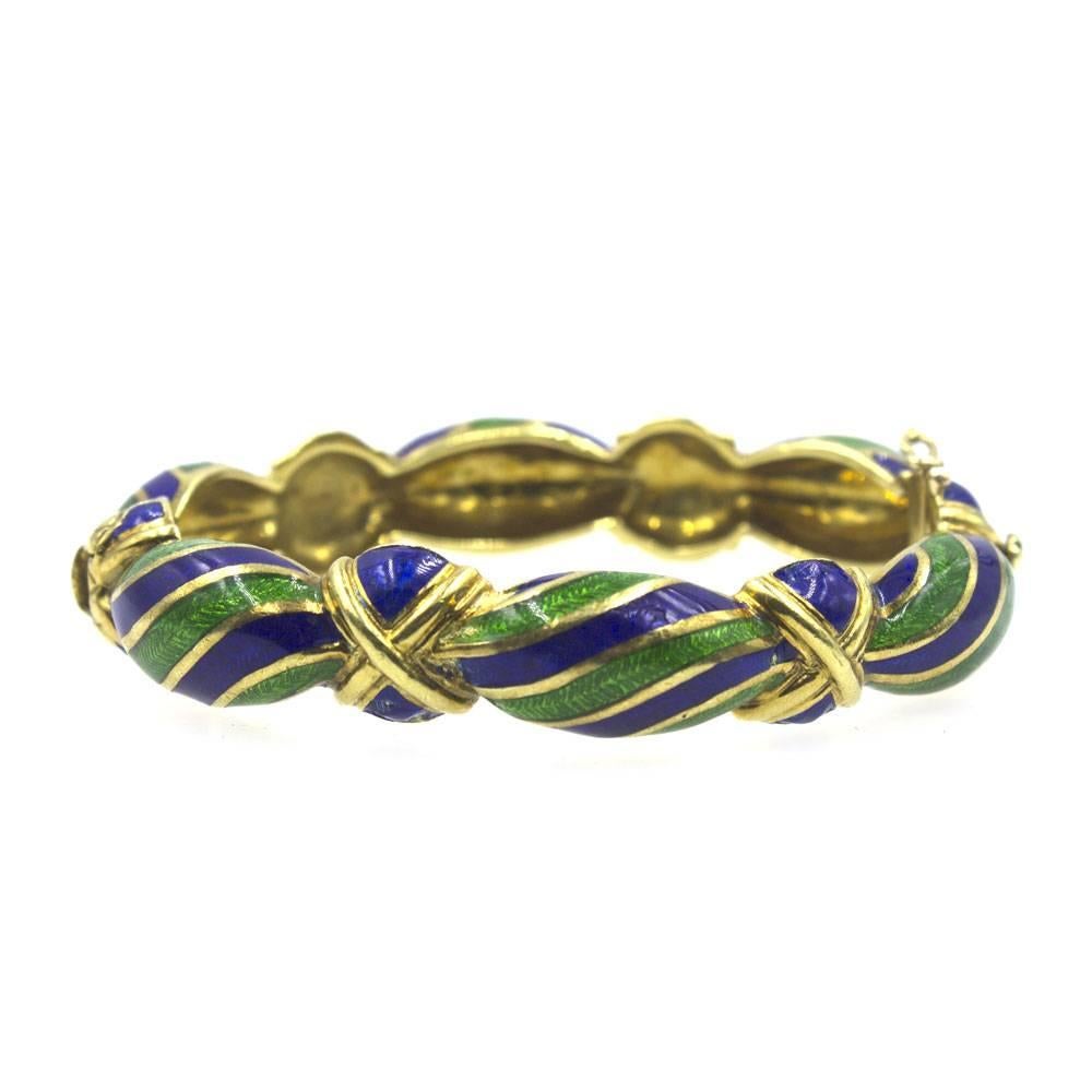 Beautiful vintage gold and enamel bangle bracelet by Tiffany & Company. This fashionable bangle features bright blue and green enamel over a solid 18 karat yellow gold bangle. Signed 18k Tiffany. The bracelet measures 2.5 inches in diameter and 12mm
