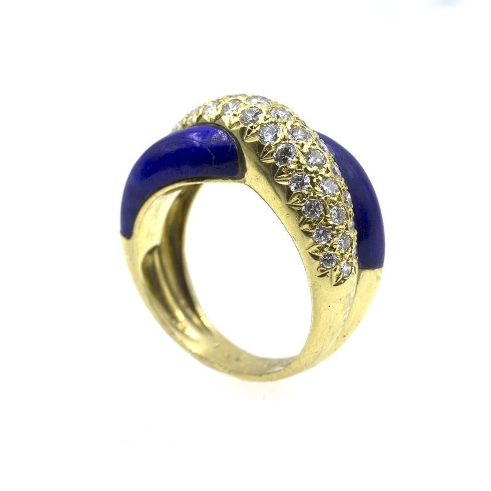 Stylish diamond and lapis crossover band ring by designer Van Cleef & Arpels. This estate ring features round brilliant cut diamonds crossing over lapis gemstone . The diamonds equal approximately .92 cttw, and are graded E/F color and VS1 clarity.