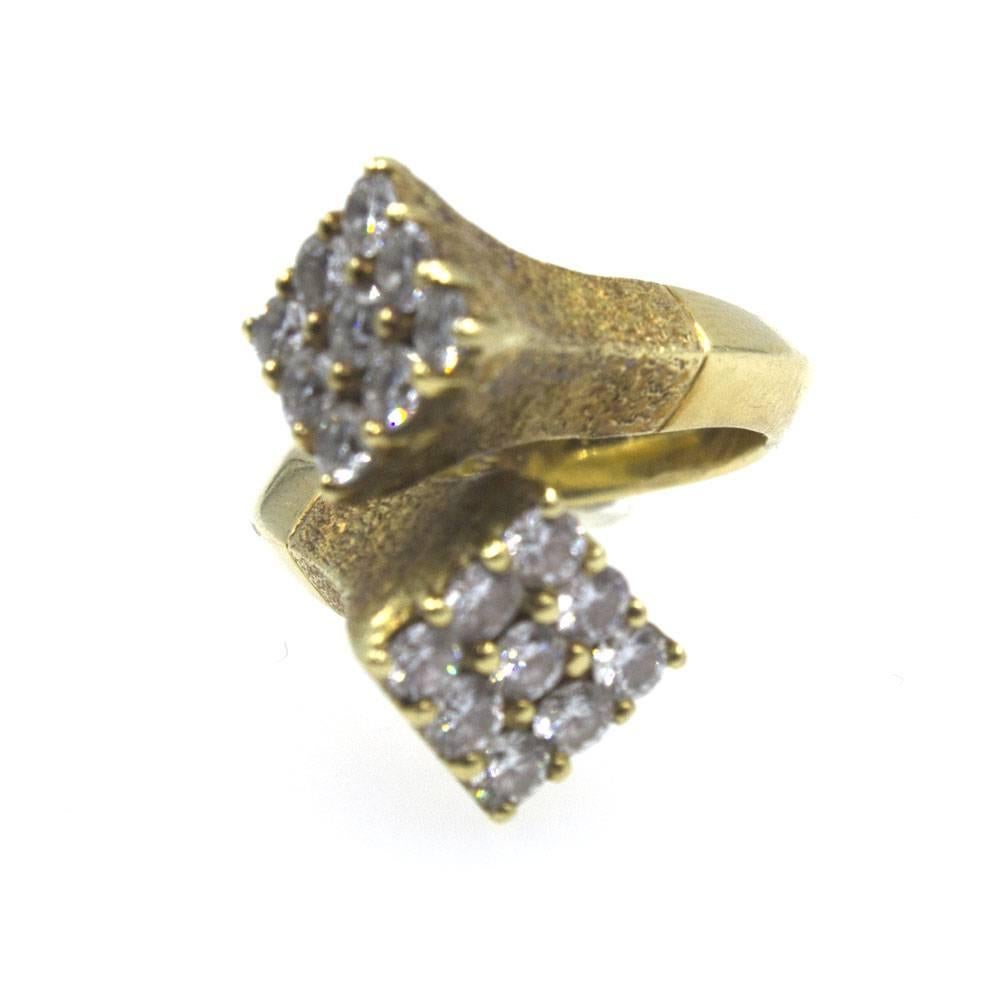 This fabulous estate diamond ring by designer GRAFF is circa 1960-1970's. The solid 18 karat yellow gold ring is textured and features muliti-diamond square ends set in a bypass fashion. There are a total of 18 round brilliant cut diamonds that