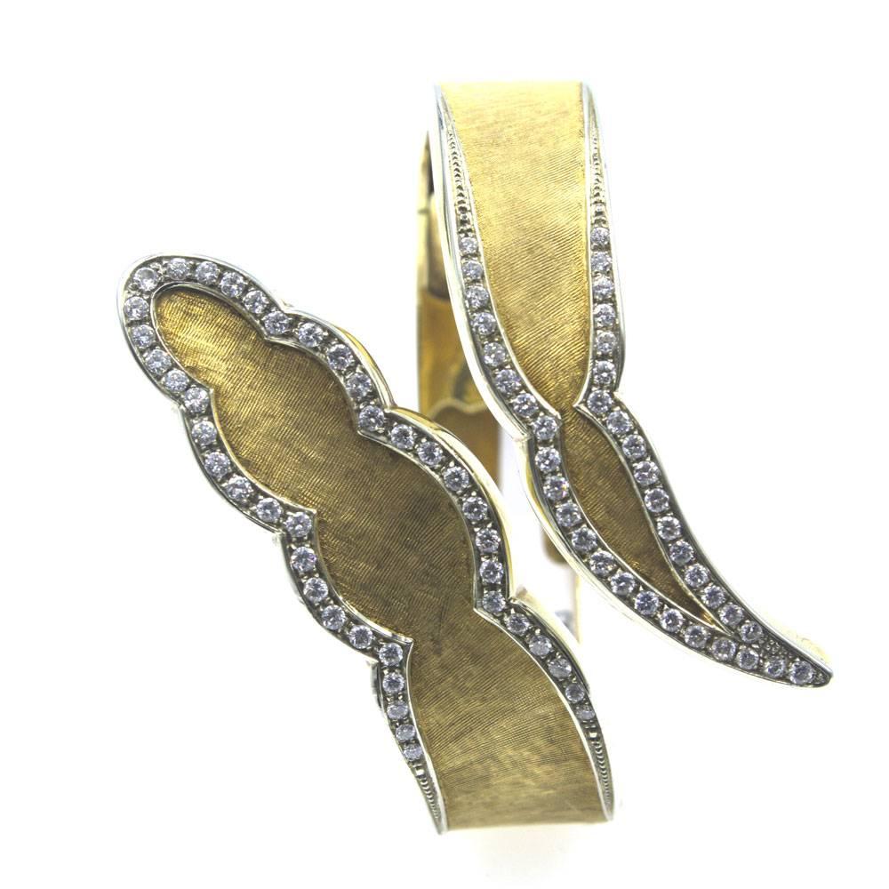 This fabulous 1970's diamond and 18 karat yellow gold bypass bracelet features 81 round brilliant cut diamonds that equal 2.5 cttw. The diamonds are graded H/I color and SI clarity. The gold has a beautiful brushed finish on the front and high