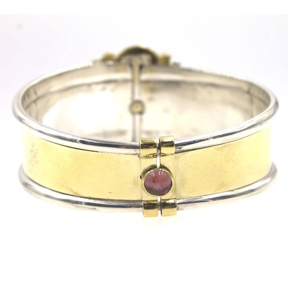 Stylish 18 karat yellow gold and sterling silver bracelet by Italian designer La Nouvelle Bague. This vintage bangle features a hinge for easy wear, and measures 7 inches in circumference, 2.3 inches in diameter, and 1.25 inches in width (widest