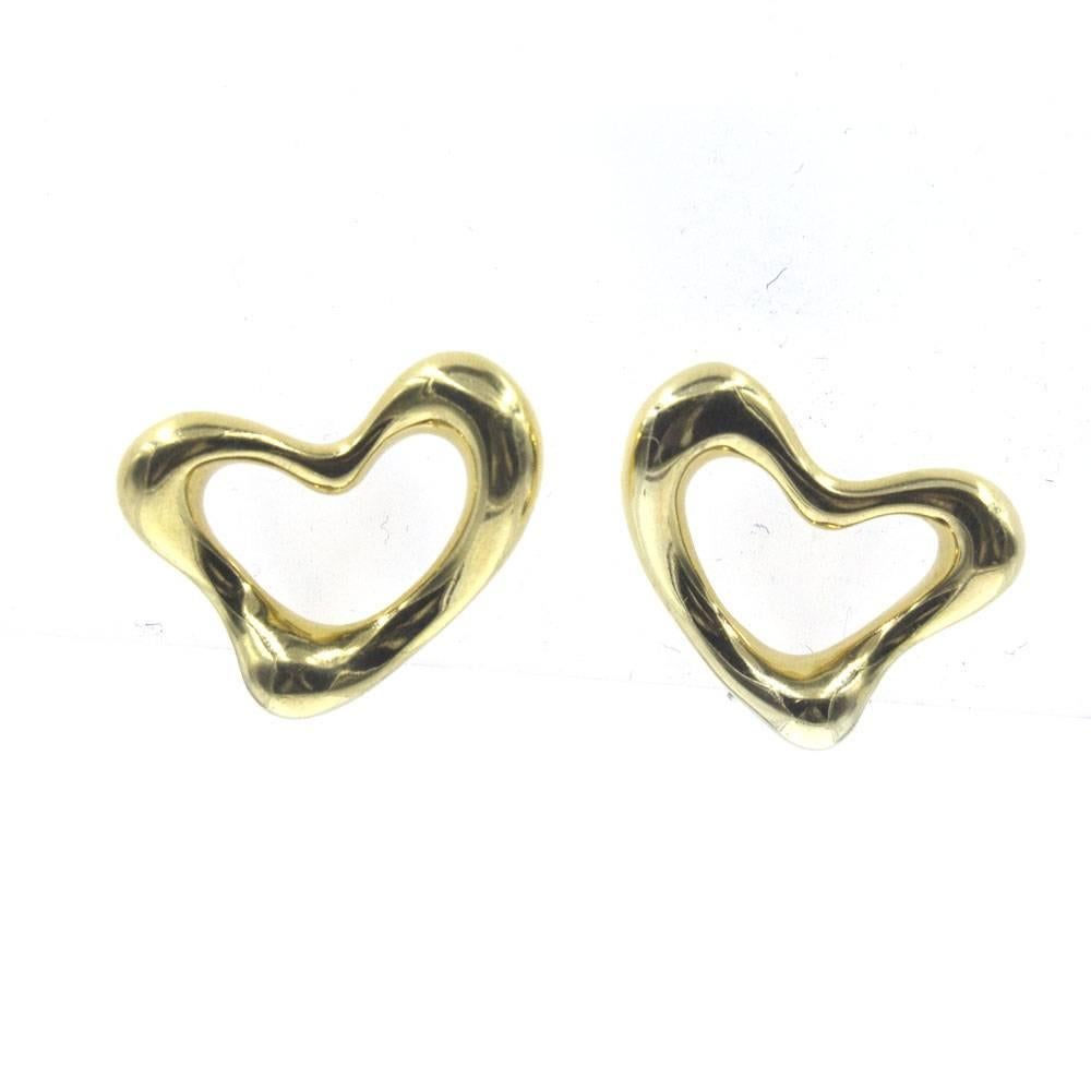 Stylish Tiffany & Company open heart earrings by designer Elsa Peretti. The clip-on earrings are fashioned in 18 karat yellow gold, measure 16mm in length, and 20mm in width. Signed Tiffany 18K Peretti. Weight: 16.2 grams. Tiffany jewelry pouch