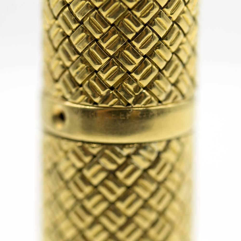 Vintage Van Cleef 18 karat yellow gold perfume bottle. The vintage perfume bottle features a textured basket weave pattern. The bottle measures 2.2 inches in length and .6 inches in width.  The bottle is signed Van Cleef &Arpels NY, and numbered.