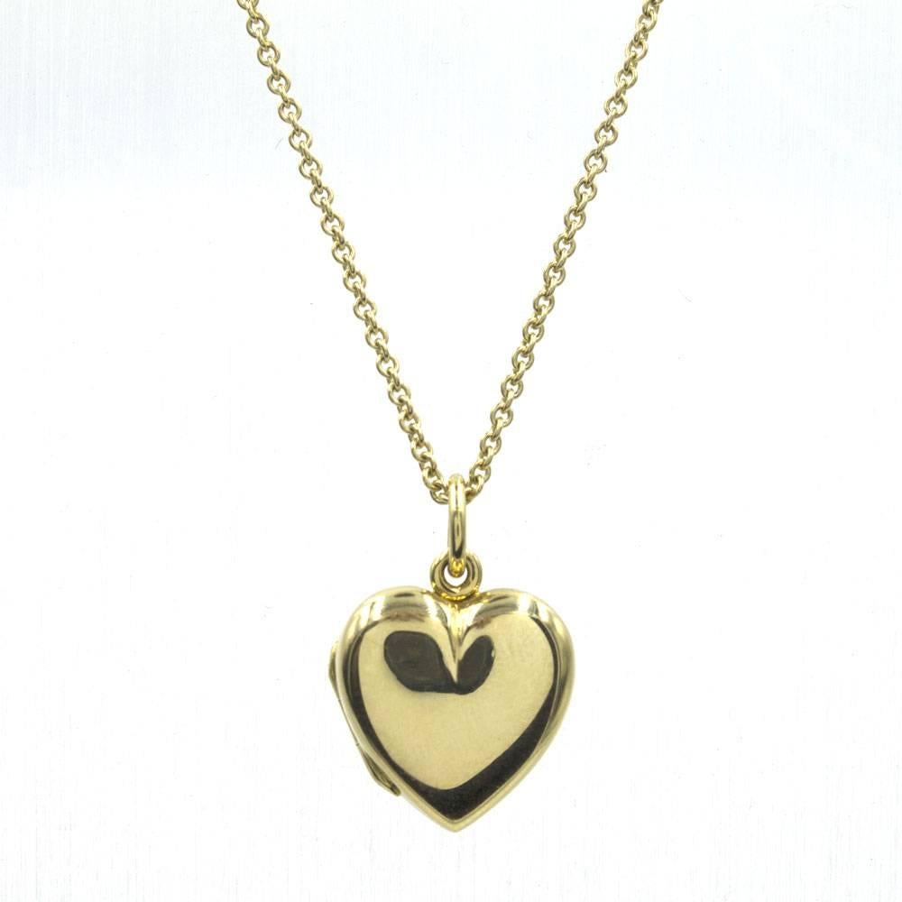 This Tiffany & Co. estate heart locket from Tiffany & Co. The heart locket measures 20 x 16mm, and comes on a 24 inch Tiffany chain. The locket and necklace are signed Tiffany & Co 585 Italy. The inside of the locket features Tiffany's