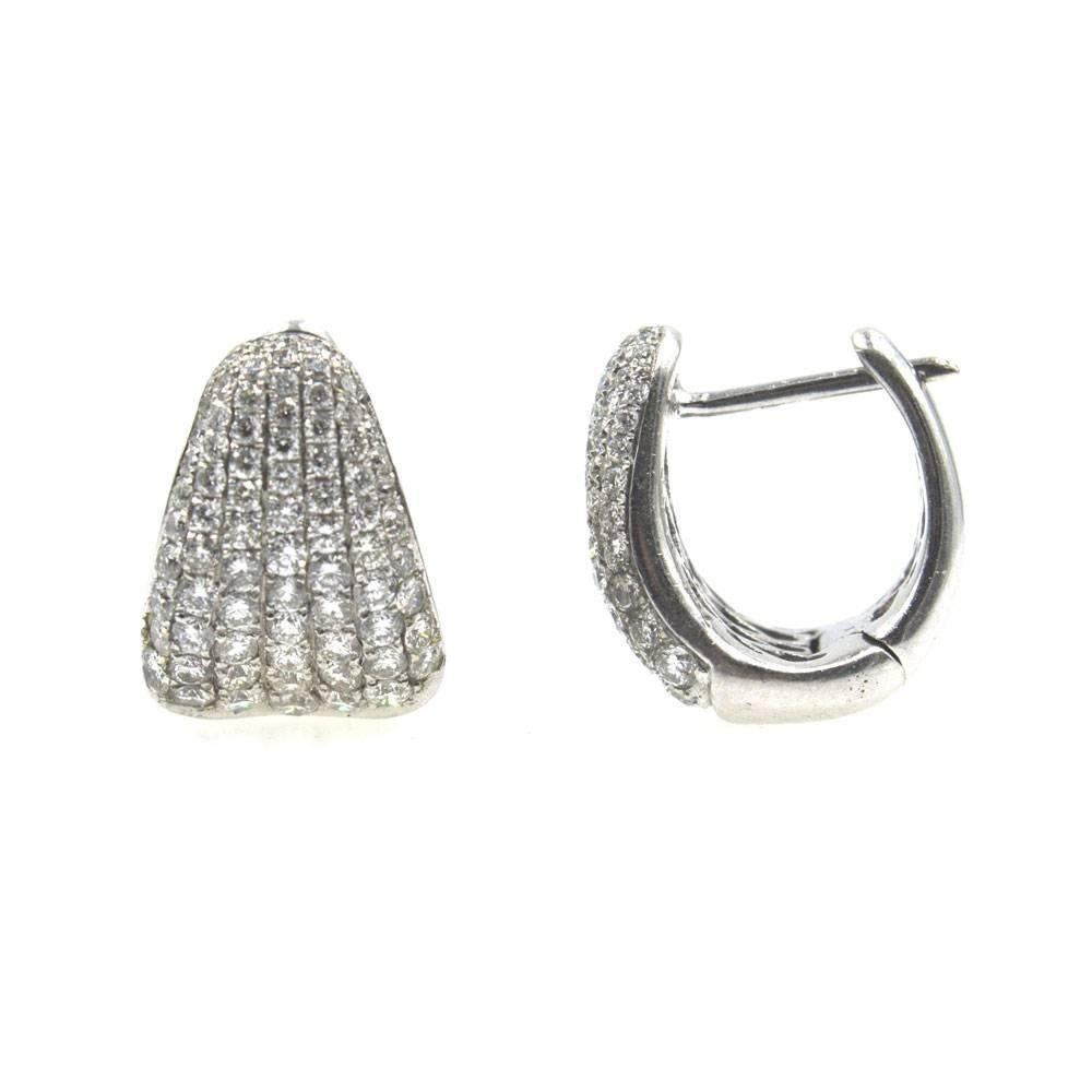Stylish diamond and white gold huggie hoop earrings. These classic earrings feature approximately 2.00 carat total weight of diamonds. The diamonds are graded G/H color and SI clarity. They measure .60 inches in length and .25 inches in width. 