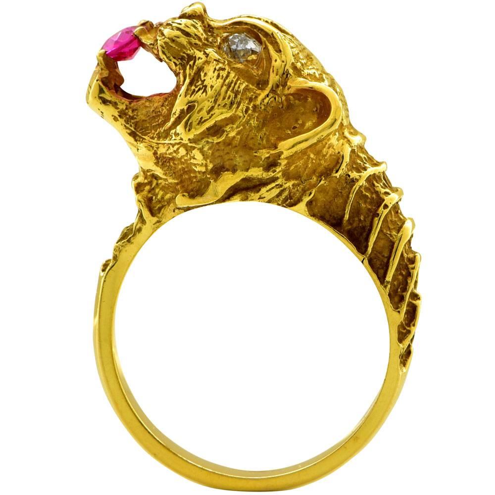 This fabulous statement panther ring is fashioned in 18 karat yellow gold. The panther features a round ruby between his teeth, and diamond eyes. The two diamonds equal approximately .15 ctw. The ring is currently size 6, but can be sized. The head