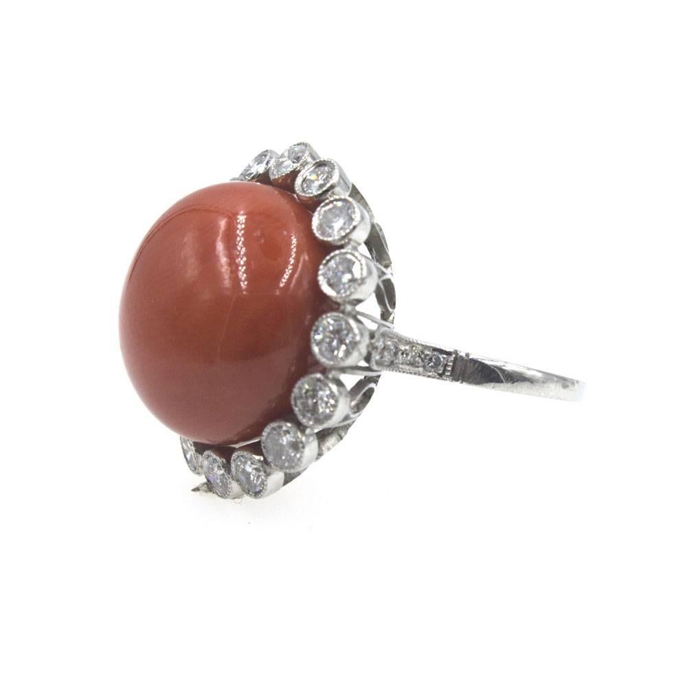 This fabulous estate ring features a beautiful color red coral gemstone surrounded by diamonds. There are 18 diamonds that equal =.80 ctw, and another .08 ctw of diamonds in the shank. The head of the ring measures 22mm in diameter, and the ring is