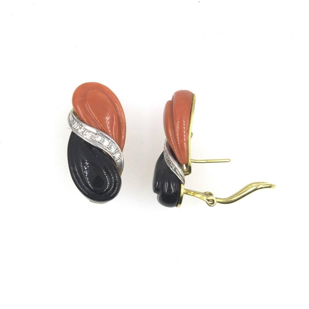 Fabulous Retro carved onyx and coral estate earrings with diamonds. These fashion earrings from the 1960's feature carved onyx and coral gemstones seperated by 14 round brilliant cut diamonds. They have omega backs and measure 13 x 28mm. 