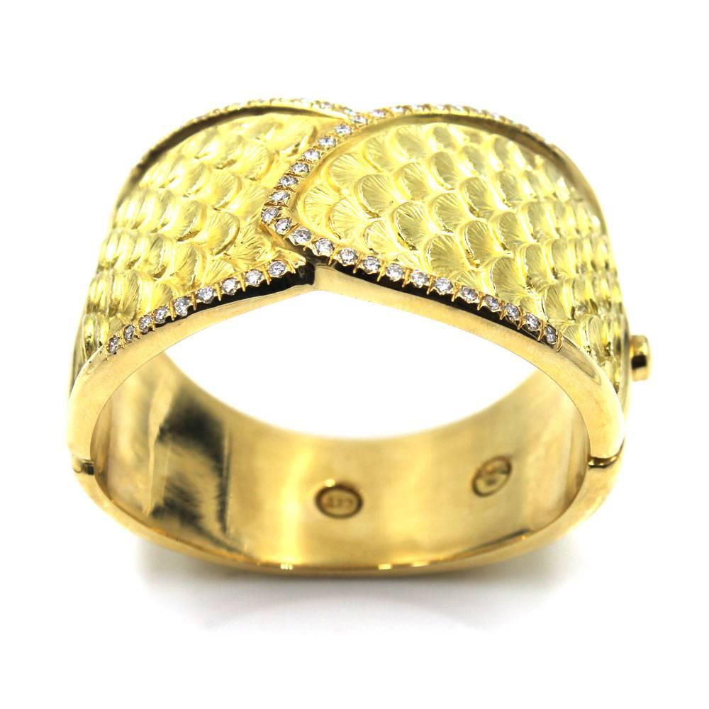 This fabulous estate hinged bangle features gold carved seashell design highlighted with round brilliant cut diamonds.The 52 diamonds outline the front of the bangle and weigh approximately 2.65 carat total weight. The diamonds are graded F-G color
