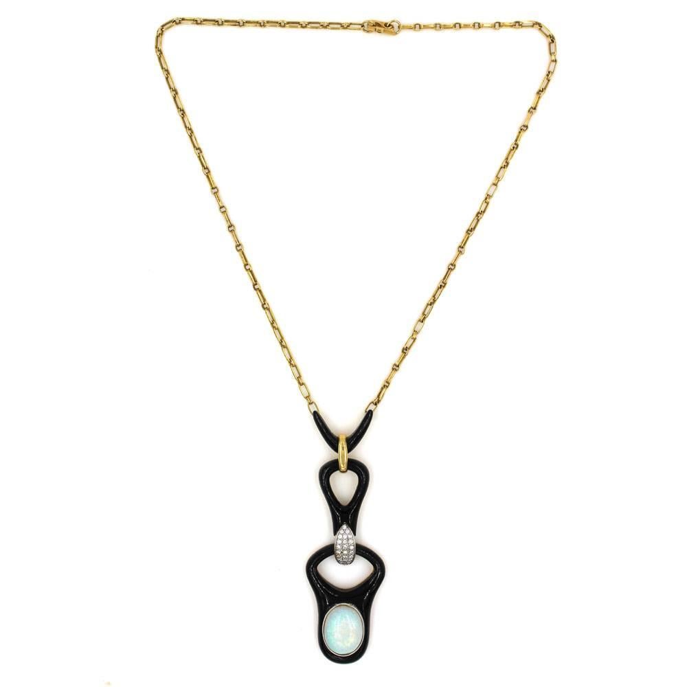 Gorgeous estate piece from the Mid-20th Century features an opal, onyx, and diamond long pendant on an 18 karat yellow gold link necklace. The opal is approximately 12 carats, and there are 22 round brilliant cut diamonds that equal approximately