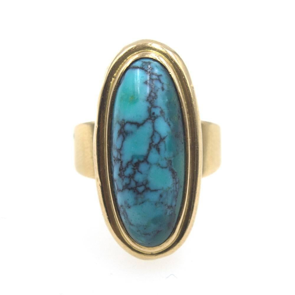 This stylish French turquoise ring is fashioned in 18 karat yellow gold. The oval shaped turquoise measures 14 x 29mm and is set into a classic mounting with French hallmarks. The ring is currently size 7.5, but can be sized. 