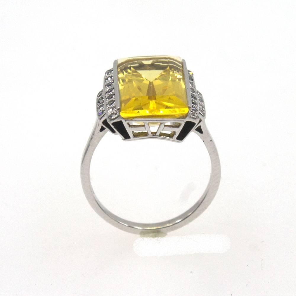 This gorgeous Art Deco ring features a faceted emerald shaped citrine gemstone and diamonds. The 24 single cut diamonds equal approximately .25 carat total weight. Black enamel is applied on the ends and adds dimension to the ring. The citrine