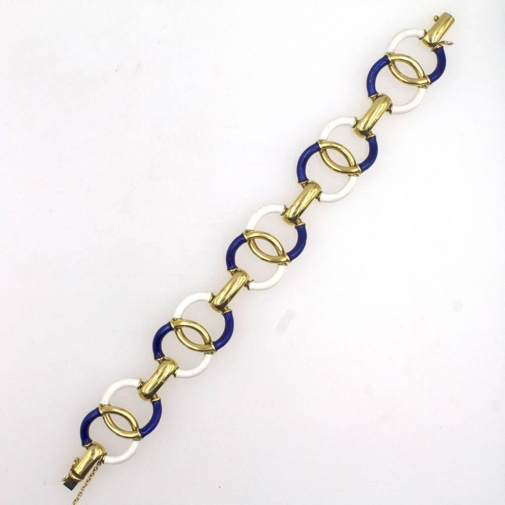 This 1970's yellow gold round link bracelet features sections of white and blue enamel. The bracelet measures 7.5 inches in length and is fashioned in 18 karat yellow gold. 