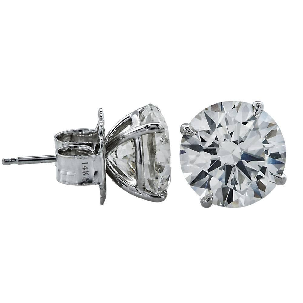 Triple Excellent Diamond stud earrings with a total carat weight of 6.92. The two round brilliant cut diamonds are graded L color, SI1-SI2 clarity, and triple excellent cut, polish, and symmetry. The brilliant diamonds are set in 18 karat white gold
