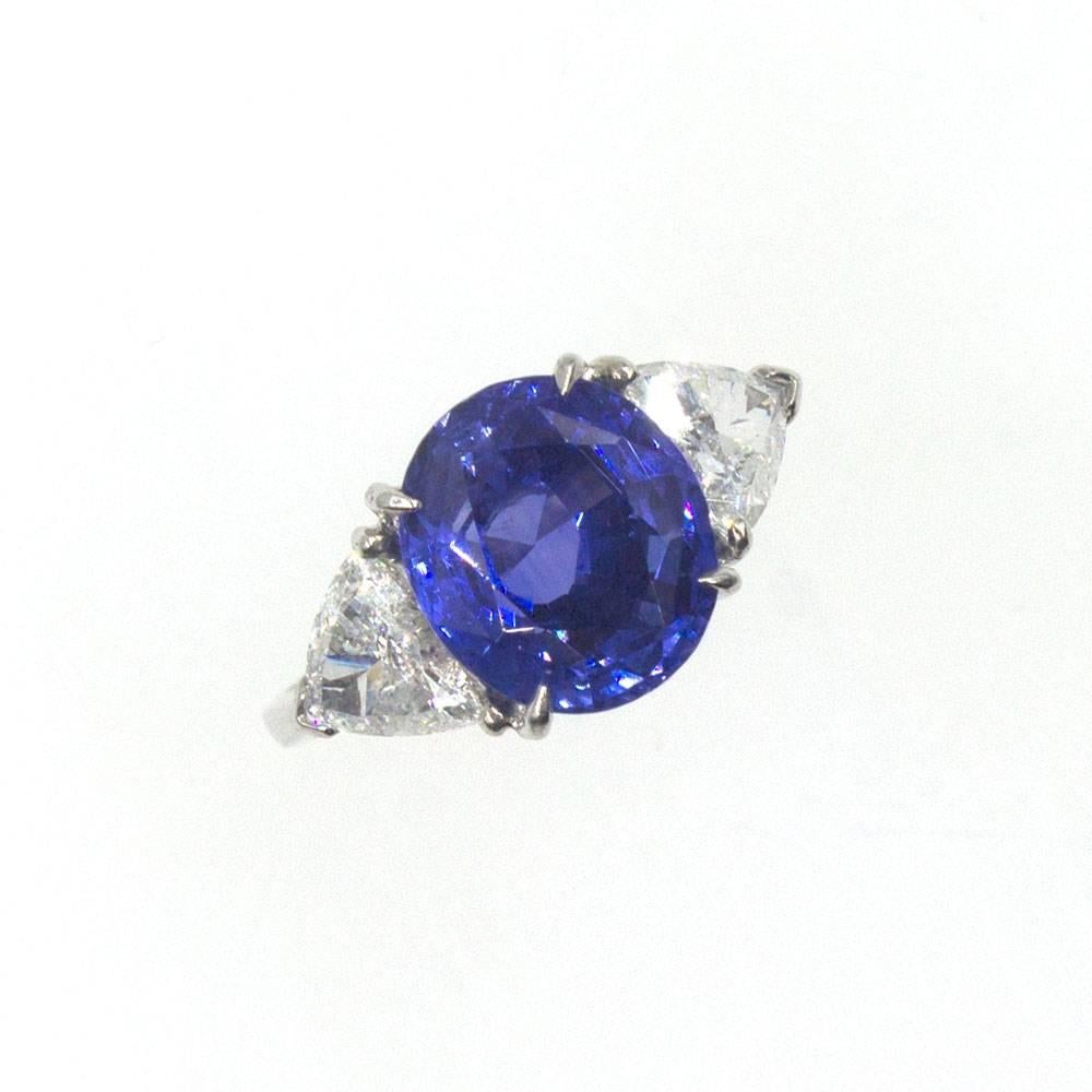 This fabulous estate ring by Asprey London features a GIA certified no heat  5.30 carat Ceylon Sapphire. The GIA certified oval shaped sapphire has a beautiful bright blue hue and is set between two triangle shaped brilliant diamonds. The two