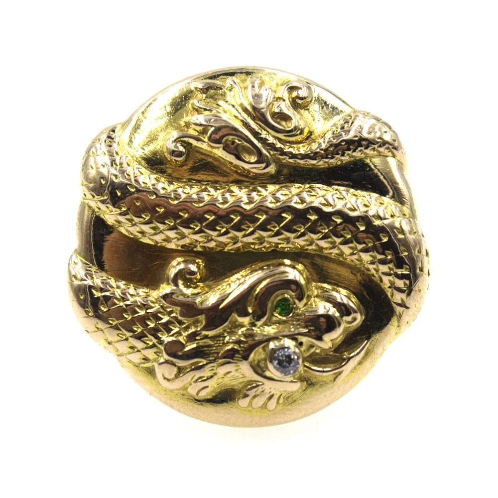 This fantastic vintage snake ring is crafted in 14 karat yellow gold and features a single diamond and emerald . The 3-D snake design adds style to this round ring. The ring is currently size 7.25 and measures 1.0 inch in diameter. 