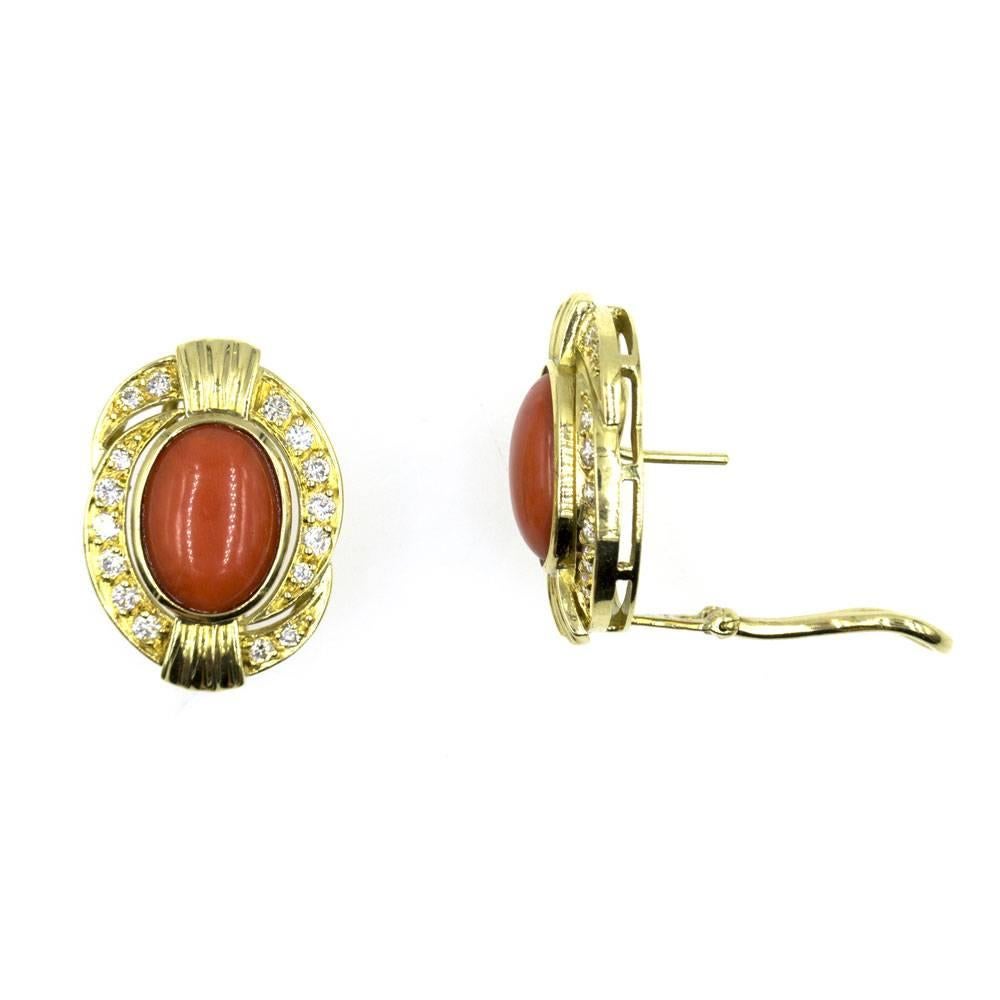 Colorful and rich red coral and diamond earrings.  These stunning earrings feature red cabochon coral surrounded by diamonds and 18 karat yellow gold. The surrounding 32 round brilliant cut diamonds, totaling .65 carat total weight, are graded G