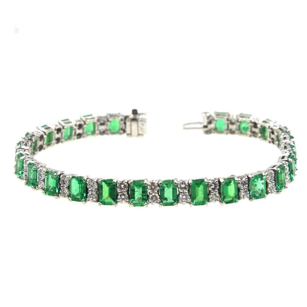 Magnificant emerald and diamond line bracelet featuring 24 matching bright green transluscent emeralds that weigh approximately 15.59 carat total weight. The bright green emeralds alternate with approximately 3.28 carat total weight of diamonds. The