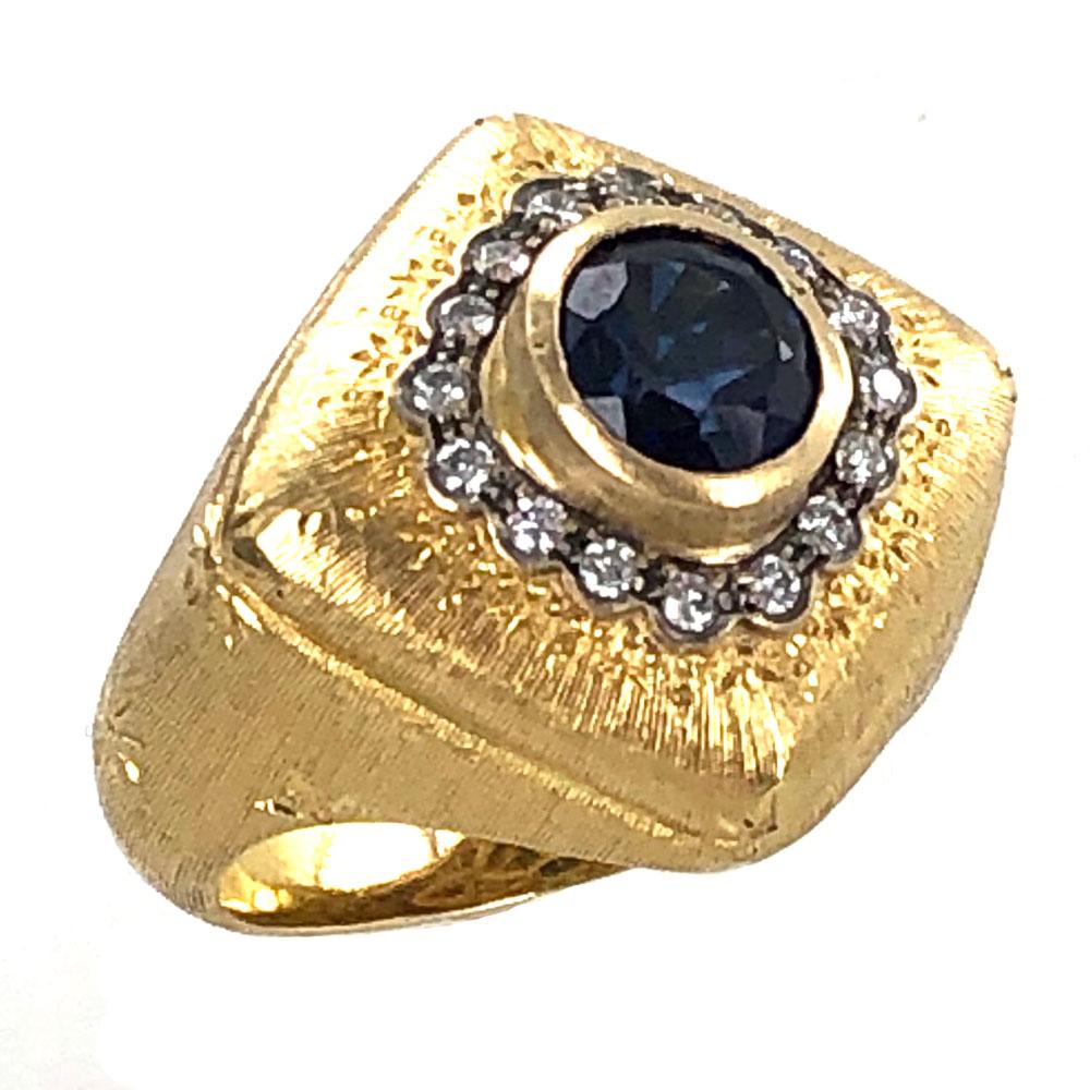 Stunning Vintage Buccellati sapphire diamond cocktail ring. The bezel set sapphire is surrounded by 16 round brilliant cut diamonds equaling approximately .25 carat total weight. The hand carved 18 karat yellow gold satin finish ring features a