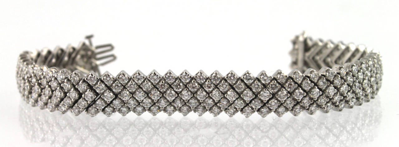 This classy 18 karat white gold bracelet is fashioned with multiple rows of diamonds. There is approximately 20.85 carats of diamonds overall, G-H color and VS-2 to SI-1 clarity. The bracelet measures 7 1/2 inches in length, and is 13 mm wide. There