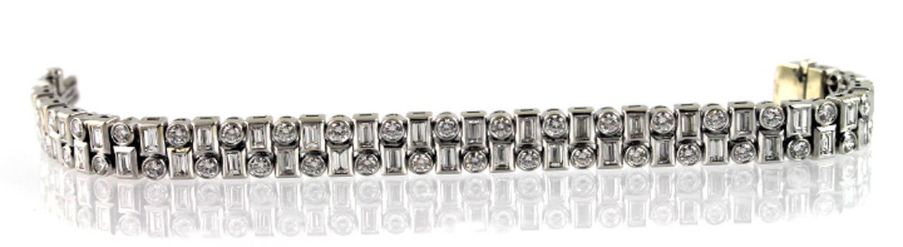This platinum diamond  two row bracelet is bezel set with alternating round brilliant and baguette cut diamonds.   There are forty four round brilliant cut diamonds weighing approximately 4 ½ carat total diamond weight and forty four straight