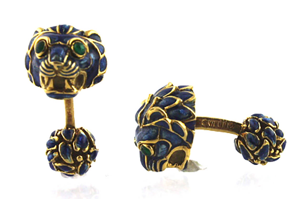 18 Karat yellow gold and enamel cufflinks and tie tac by renowned jewelry designer Webb. The set is fashioned as a lion head with blue enamel and cabochon emerald eyes. The cufflinks are traditional style with an enamel ball end. The cufflinks