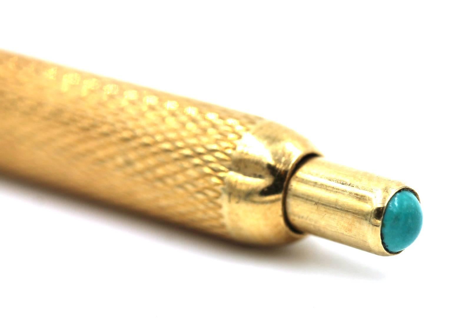  Van Cleef and Arpels 14 karat yellow gold ball point style pen with click open and closure. The pen has a textured finish and the spring has a round cabochon turquoise stone bezel set at the top. The pin is signed VC&A 14K, and is 4 inches in