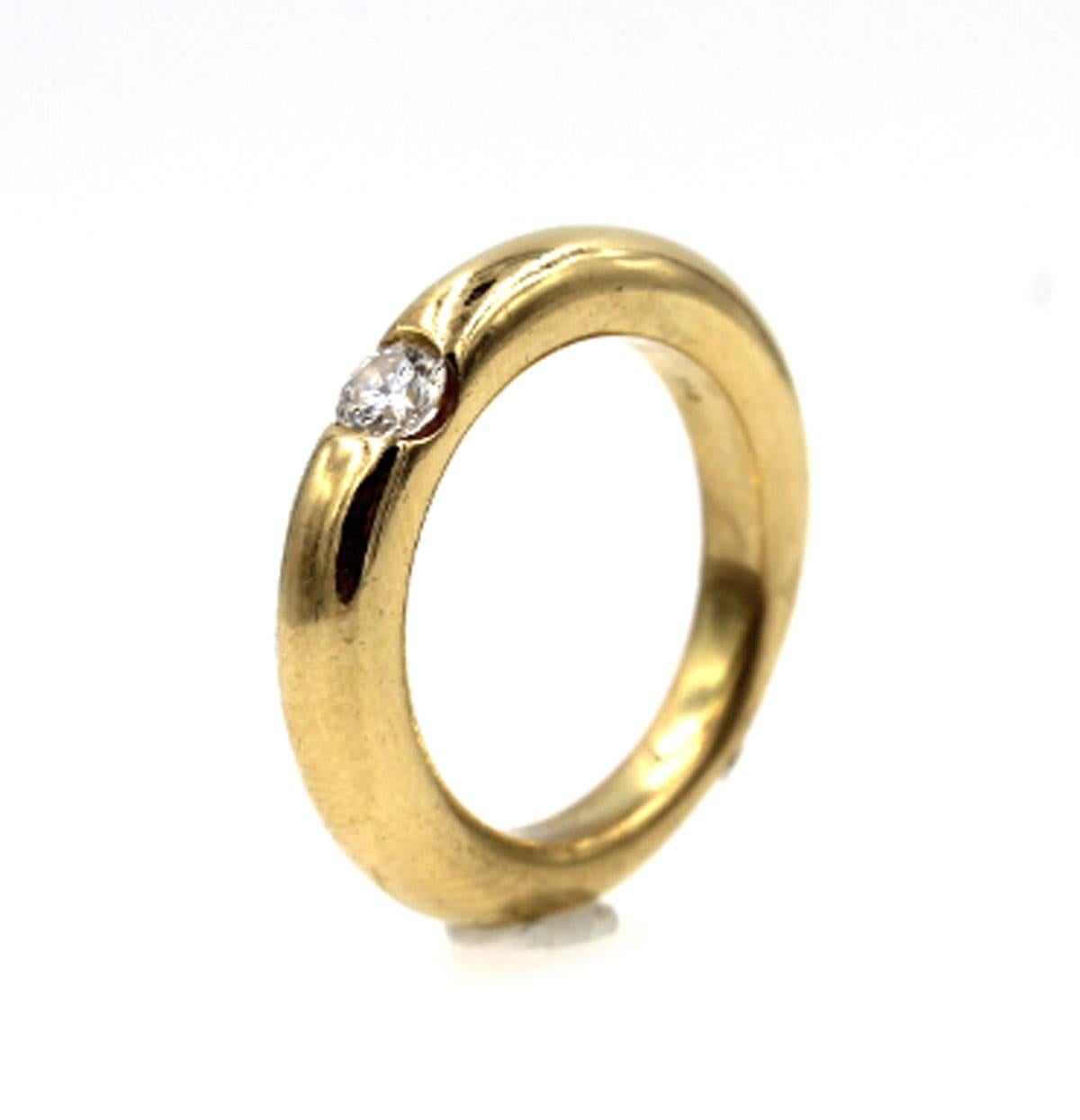 Cartier Ellipse Diamond Ring in 18 Karat Yellow Gold. The ring features a single round brilliant cut diamond equaling 1/4 carat total weight. Signed Cartier, and is US size 5 3/4. Can be worn alone or stacked with other rings. 