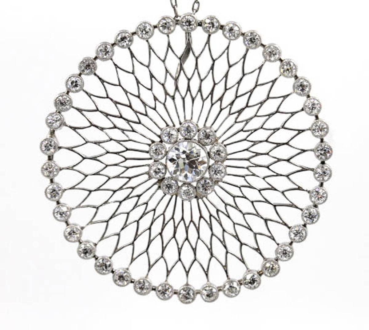 This beautiful Edwardian pendant features a center 1 1/4 carat Old European Cut diamond surrounded by 48 side diamonds that equal approximately 3 carat total weight. The circle pendant measures 1 3/4 inches in diameter, and is hung on a 17 inch