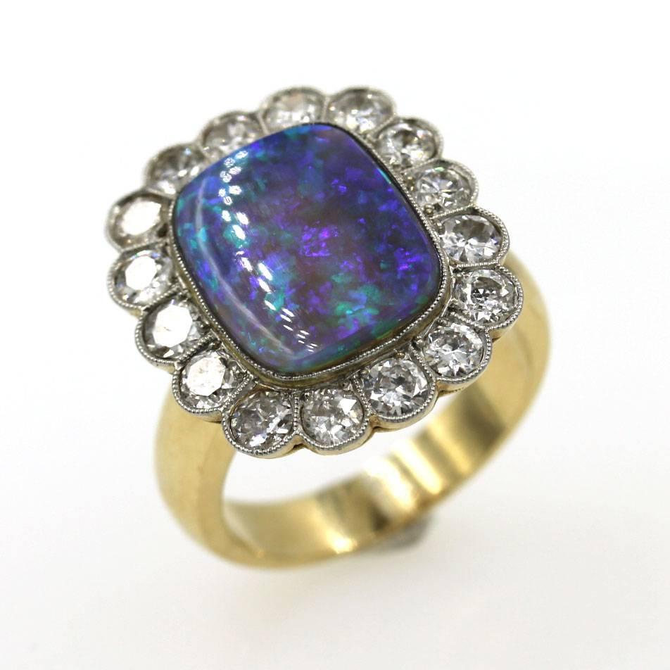 This fabulous black opal and diamond ring features 16 Old European cut diamonds that equal 2.25 carat total weight. The diamonds surround an approximately 5 carat high quality black opal. The ring is 18 karat yellow gold, and currently size 8, but