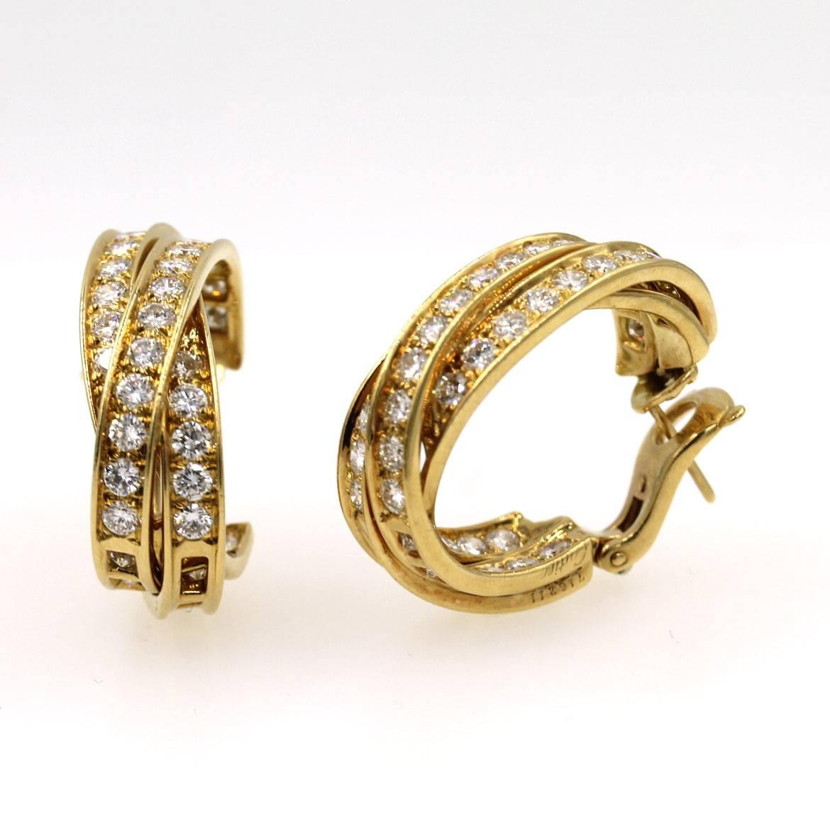 These timeless diamond in/out hoop earrings by Cartier are circa 1990's ( this size is retired from the collection). The earrings feature 82 round brilliant cut diamonds that equal approximately 5.0 CTTW graded E/F color and VVS clarity. 