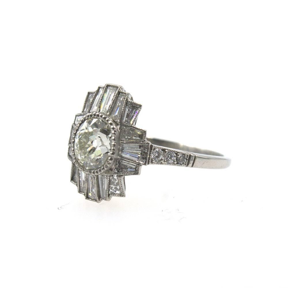 Spectacular Art Deco inspired diamond engagement ring features an 1.11 carat Old Mine cut diamond with a GIA certificate. The diamond is graded M color and VS2 clarity. The fabulous platinum mounting features 6 Old European cut diamonds and 16