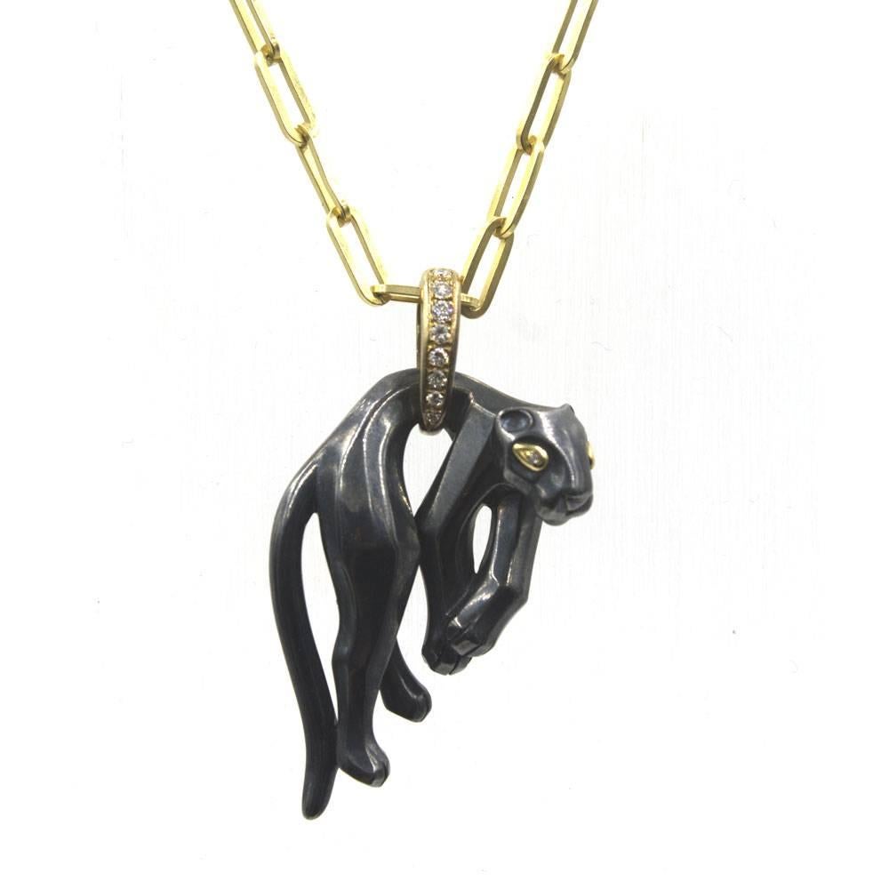 This fabulous rare Cartier pendant features a hanging Panther carved from hematite with diamond eyes and baile. The panther is hanging from the 18 karat yellow gold diamond baile. The Panther is the symbol of the House Cartier, at the same time