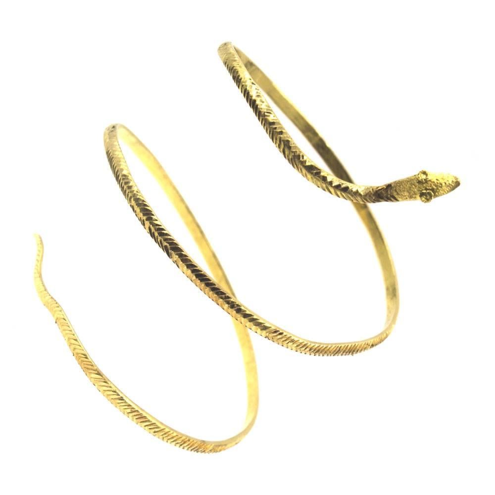 The beautiful color of 22-Karat gold is used to create this stylish wide snake bracelet. The attention to detail is noted in the textured snake like exterior from face to tail, and smooth interior. The bracelet measures 3.5 inches in width from head