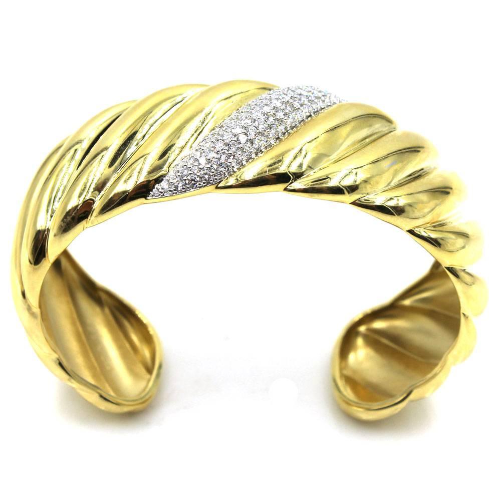 This beautiful diamond 18 karat yellow gold cuff bracelet was designed by David Yurman. The cuff features 97 round brilliant cut diamonds that equal approximately 1.50 carat total weight. Sculpted in design, the bracelet measures 7 inches in