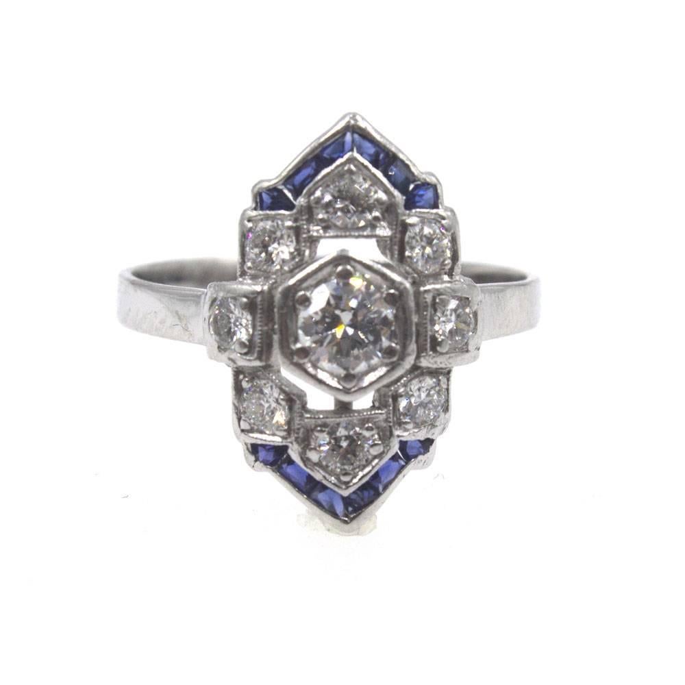 This beautiful Art Deco ring features old world diamonds and accent sapphires. The platinum ring is set with 9 Old European cut diamonds that equal approximately .50 carat total weight. The top and bottom of the ring is designed with a blue sapphire
